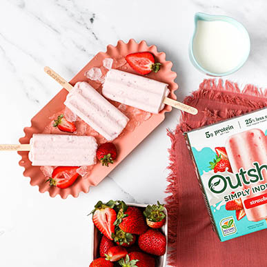 Outshine strawberry fruit bars on a plate with strawberry slices