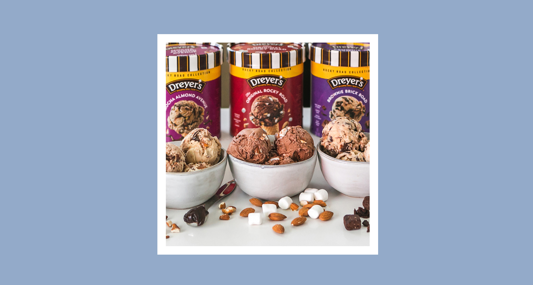 Three cartons of Dreyer's rocky road ice cream with behind bowls of ice cream