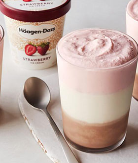 Glass of Haagen-Dazs Neapolitan strawberry vanilla milkshake