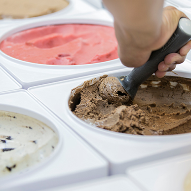 Cartons of Haagen-Dazs ice cream in cooler with an ice cream scoop