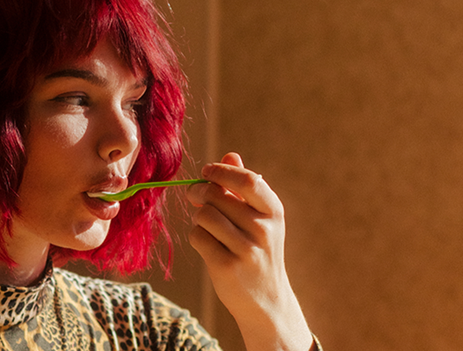 woman with red hair taking bite of ice cream