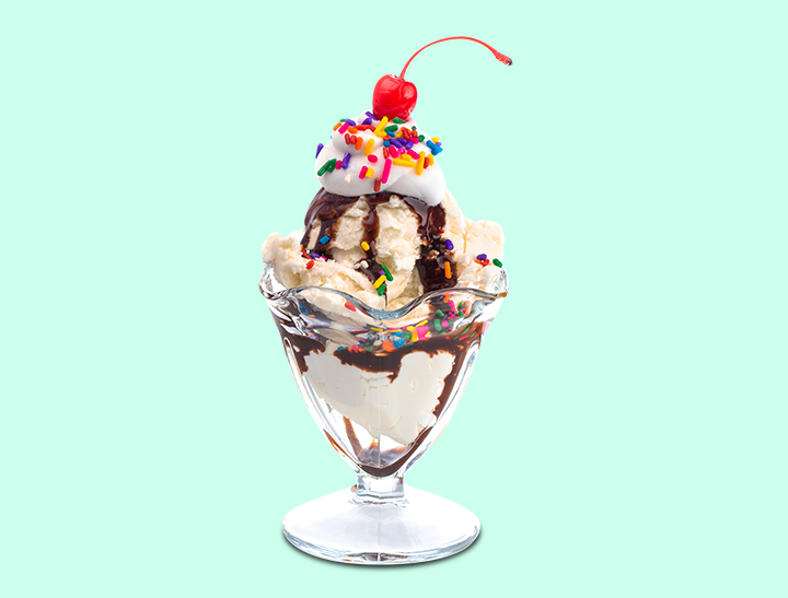 ice cream sundae with chocolate syrup, rainbow sprinkles and cherry