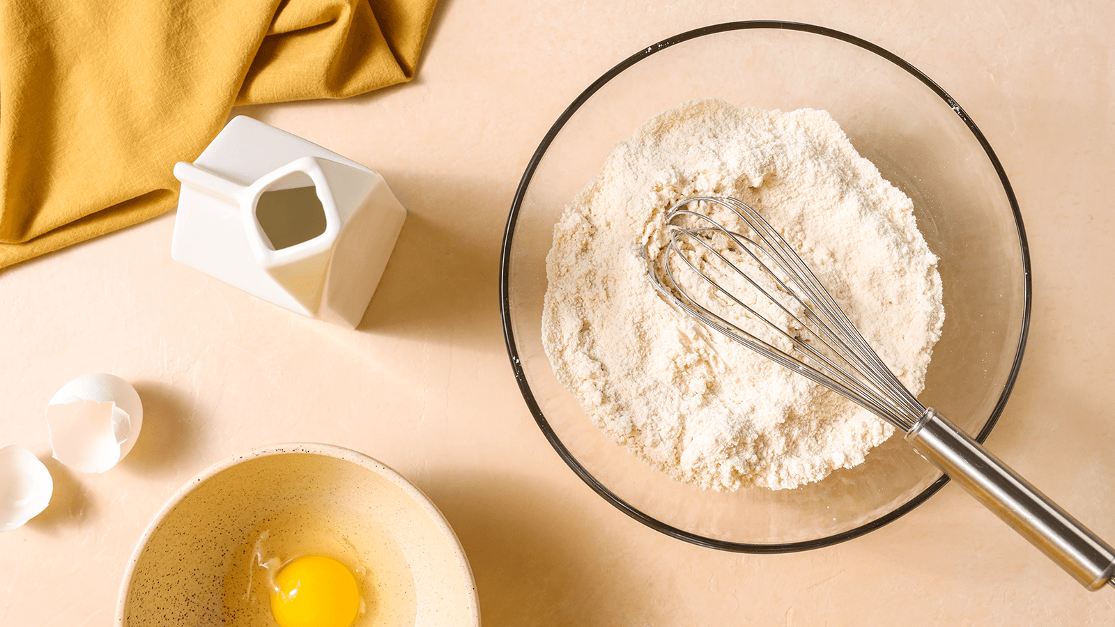 Bowl with flour and whisk bowl with egg