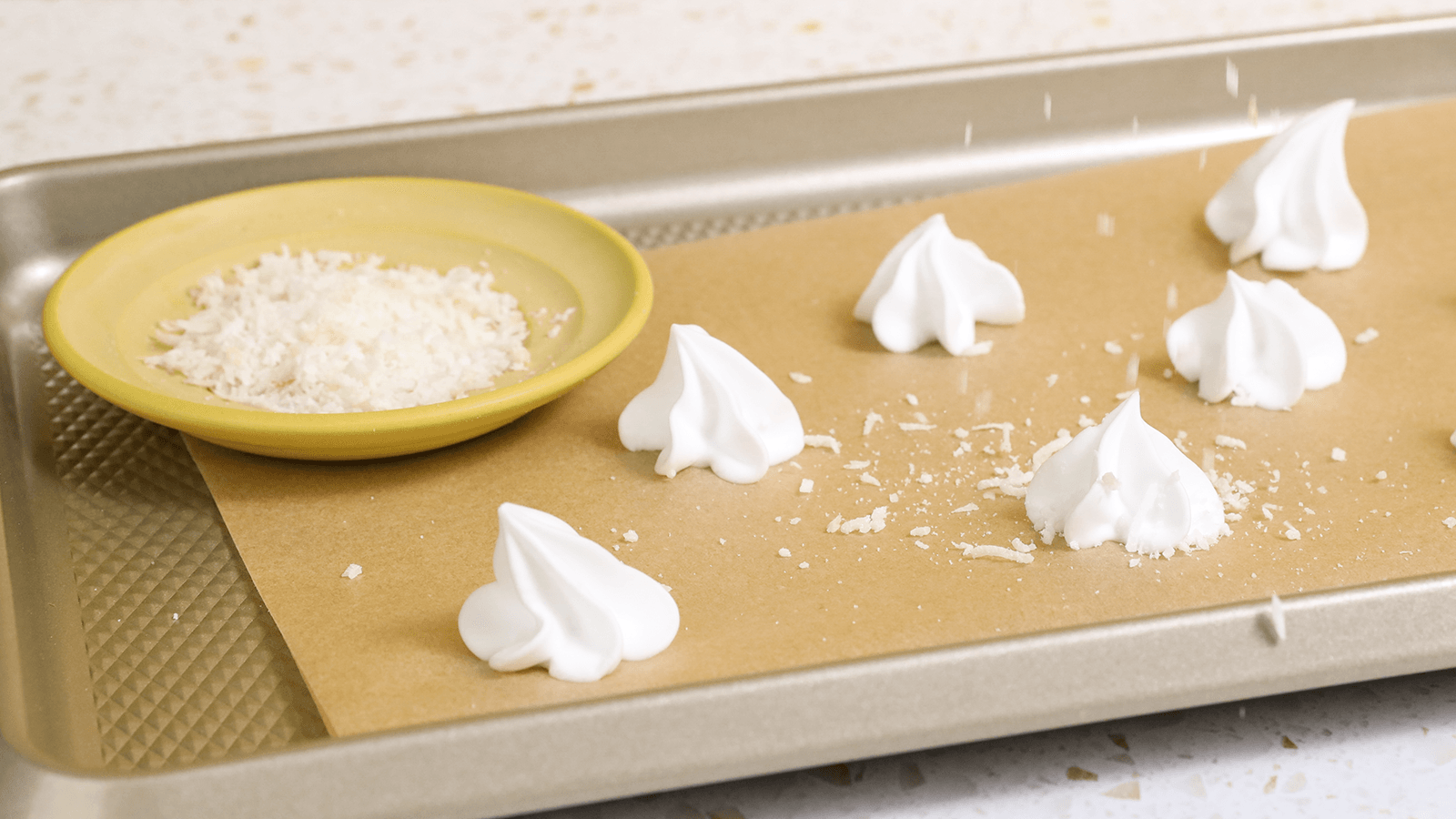 meringue with sprinkled coconut on baking sheet