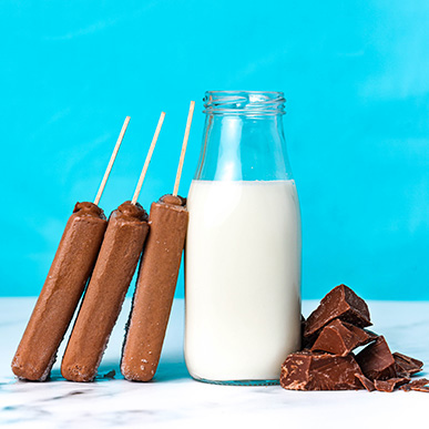Outshine chocolate bars with jar of milk and pieces of chocolate