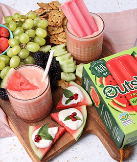 Outshine watermelon fruit bars, sliced watermelon and smoothie on a snack board